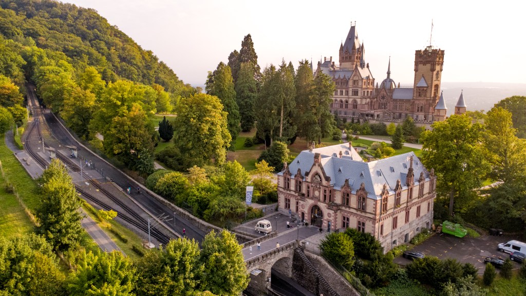 Luftaufnahme im Siebengebirge mit Schloss Drachenburg am bewaldeten Hang.